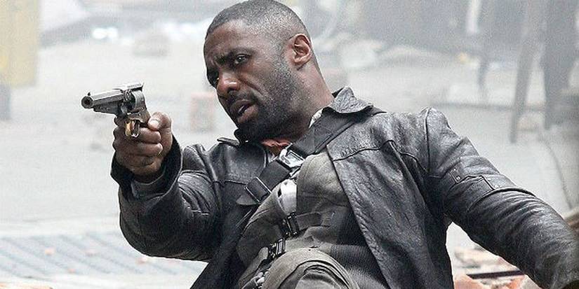 Idris Elba firing a gun while seated in The Dark Tower