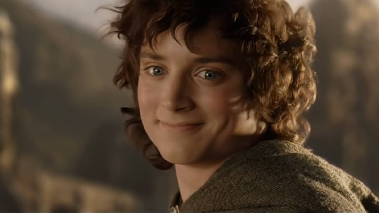 A still from The Return of the King of Frodo, played by actor Elijah Wood, smiling as he departs for the Gray Havens. 