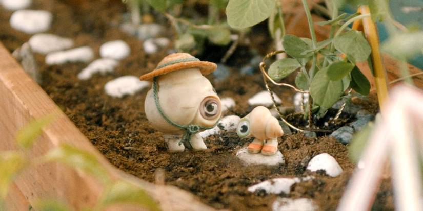 Two seashells with eyes stand in a garden in Marcel the Shell with Shoes On.