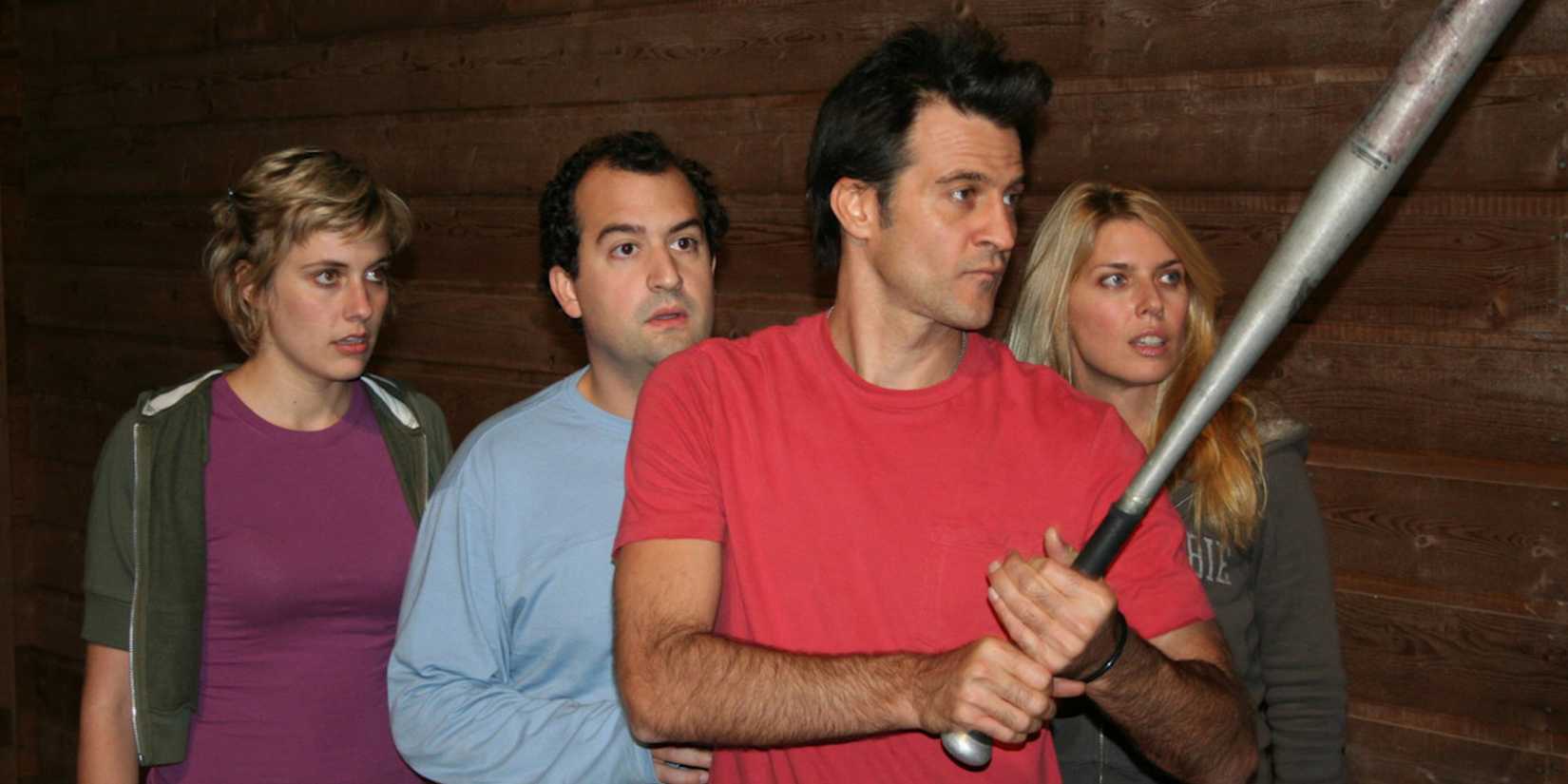 Michelle (Greta Gerwig), Chad (Steve Zissis), and Catherine (Elise Muller) standing behind Matt, who holds a baseball bat, in Baghead