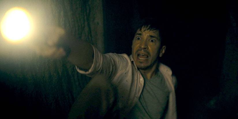 Justin Long is in fear as he shines a light in Barbarian 