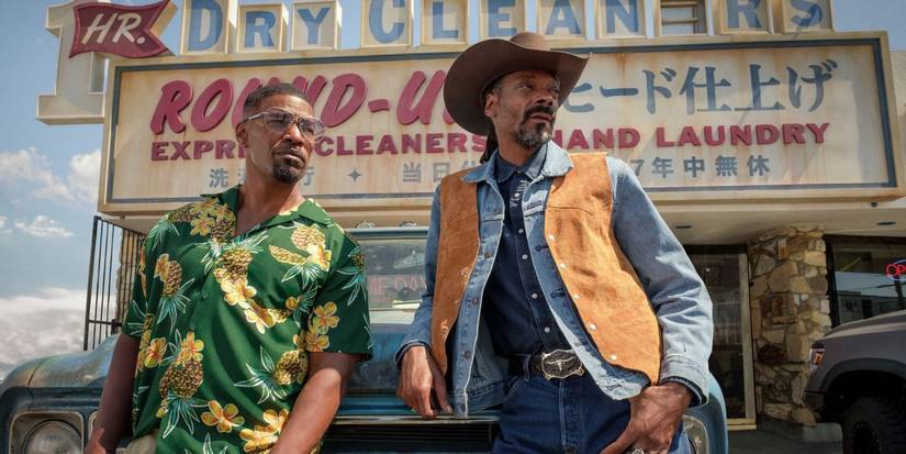 Jamie Foxx and Snopp Dogg leaning on a car in Day Shift