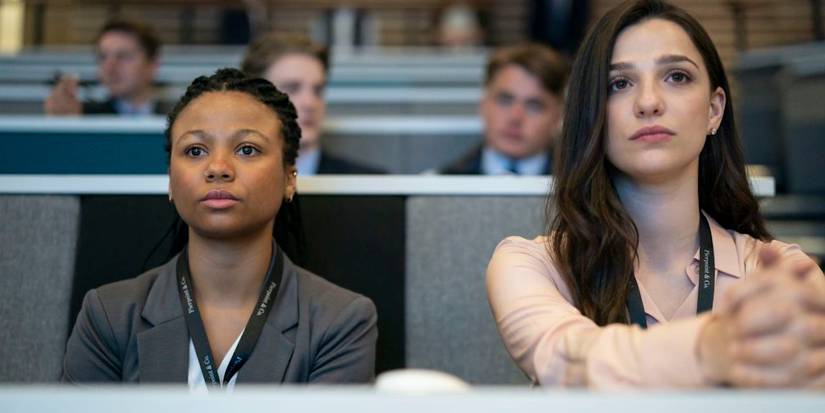 Two young woman sitting in a classroom paying attention intently in a scene from Industry.