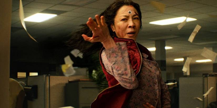 Michelle Yeoh como Evelyn, peleando mientras hojas de papel vuelan a su alrededor en Everything Everywhere All at Once.
