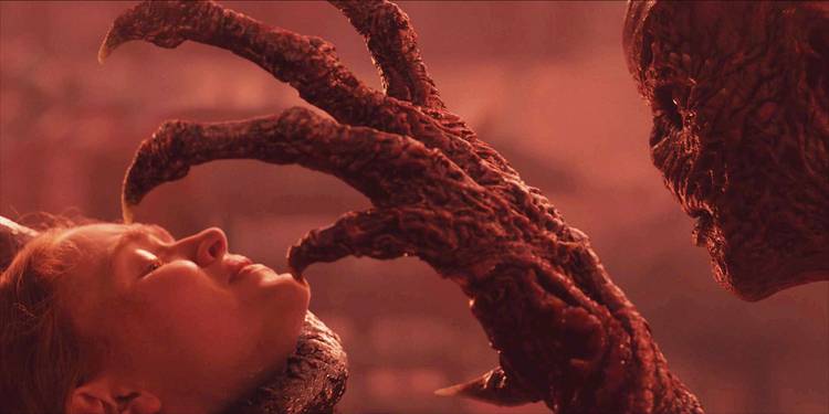 Vecna holds a large, clawed hand toward Max's face as she's held by the throat in Stranger Things.