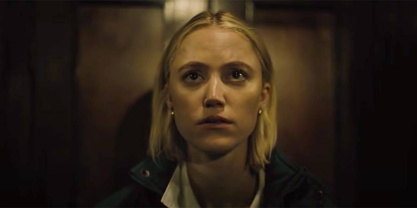 Maika Monroe as Julia looking up at a person offscreen in 2022's Watcher