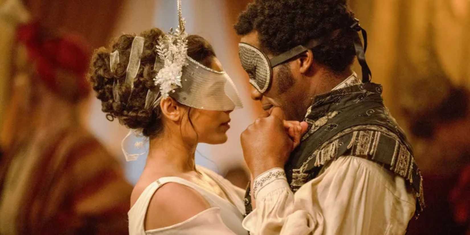 Mr. Malcolm and Selina Dalton, who are dressed for a fancy masquerade ball, dance together in a ballroom.