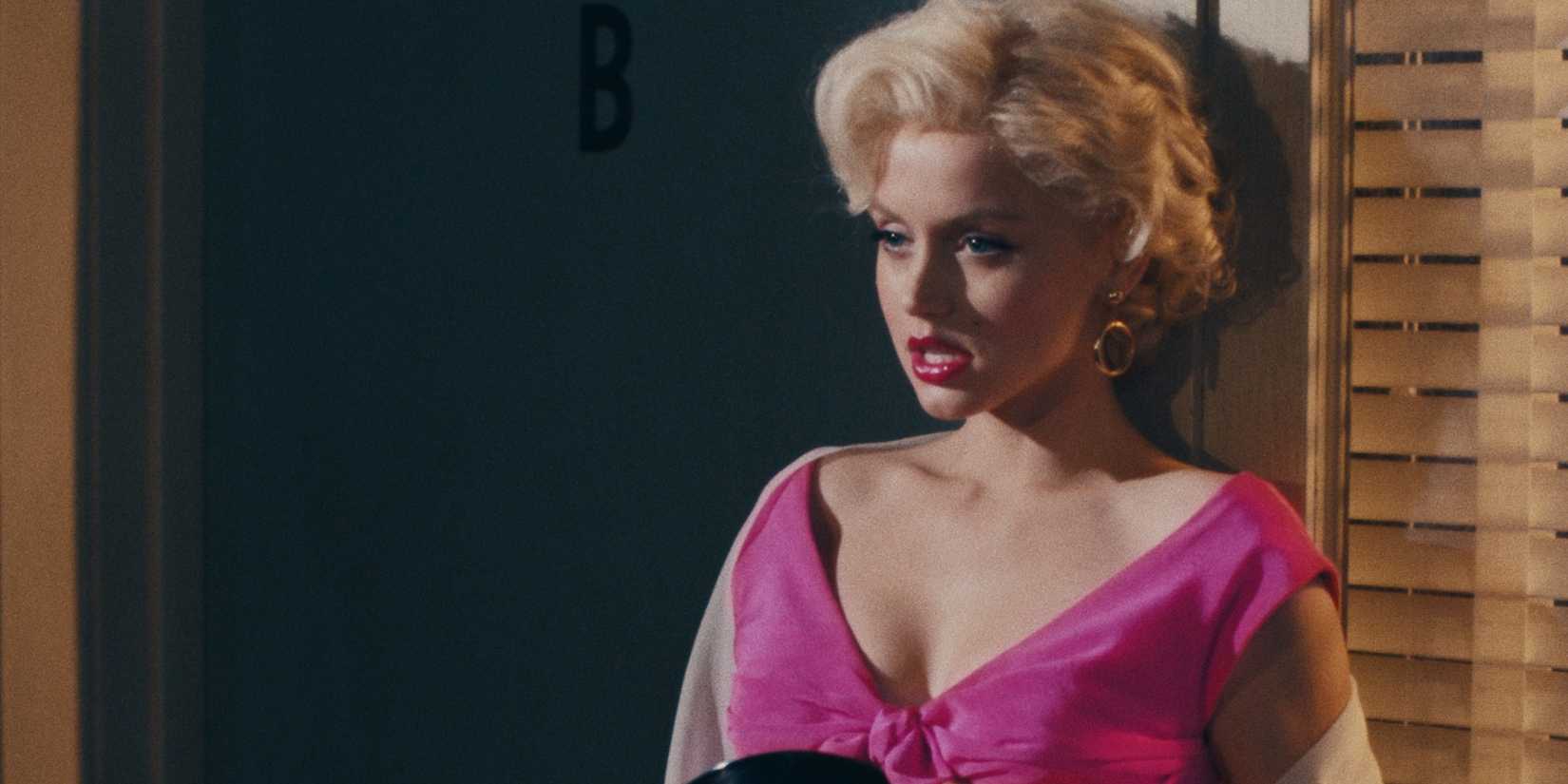 Ana De Armas as Marilyn Monroe in a pink dress and red lipstick in 'Blonde.'