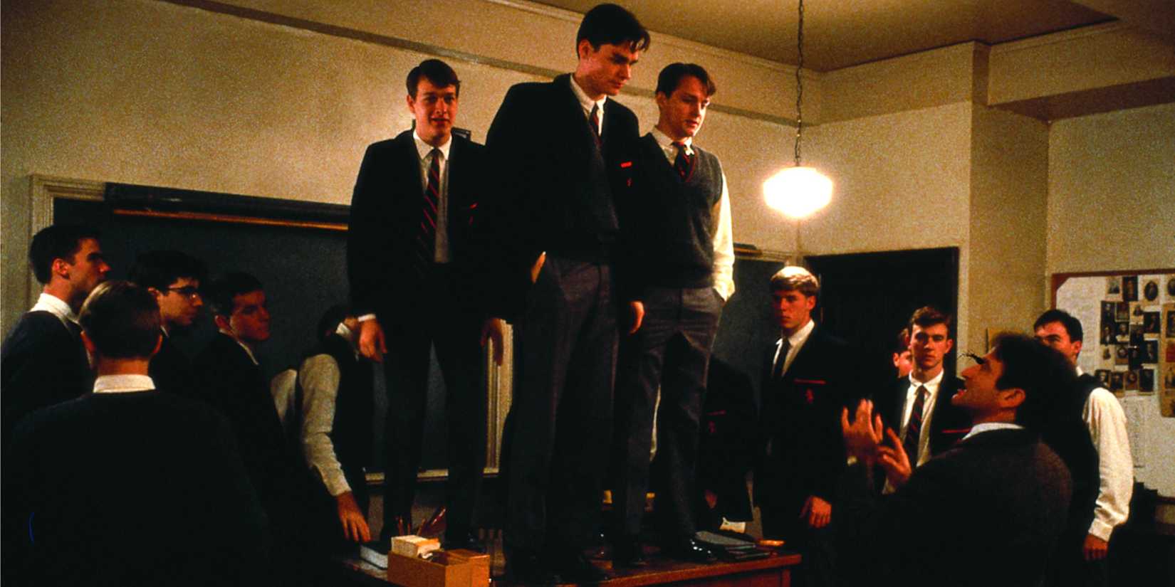 The class standing up on desks looking down at John Keating (Robin Williams) in Dead Poets Society