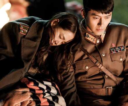 Yoon Se Ri and Ri Jeong Hyeok from Crash Landing On You sitting near a bonfire.
