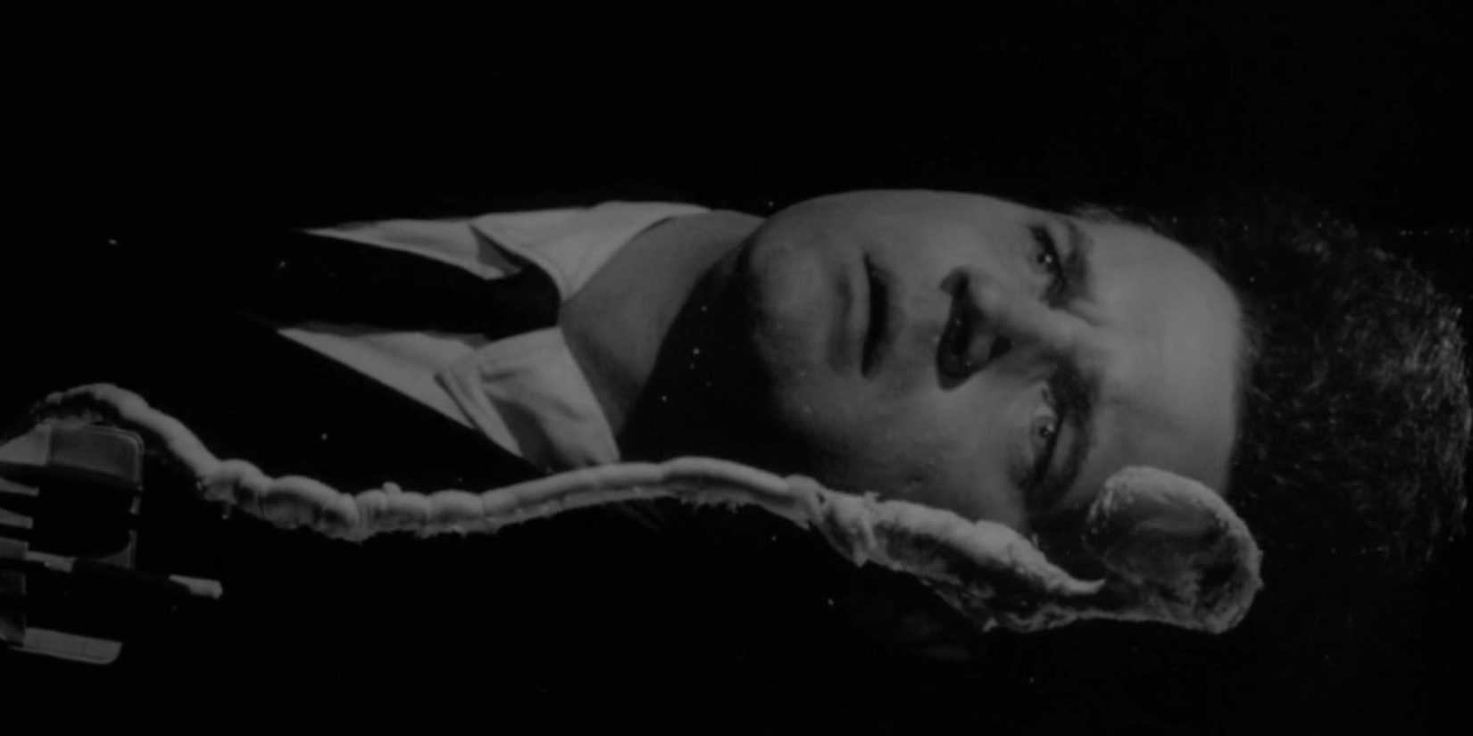 An oversized Jack Nance floating in darkness in Eraserhead (1977)