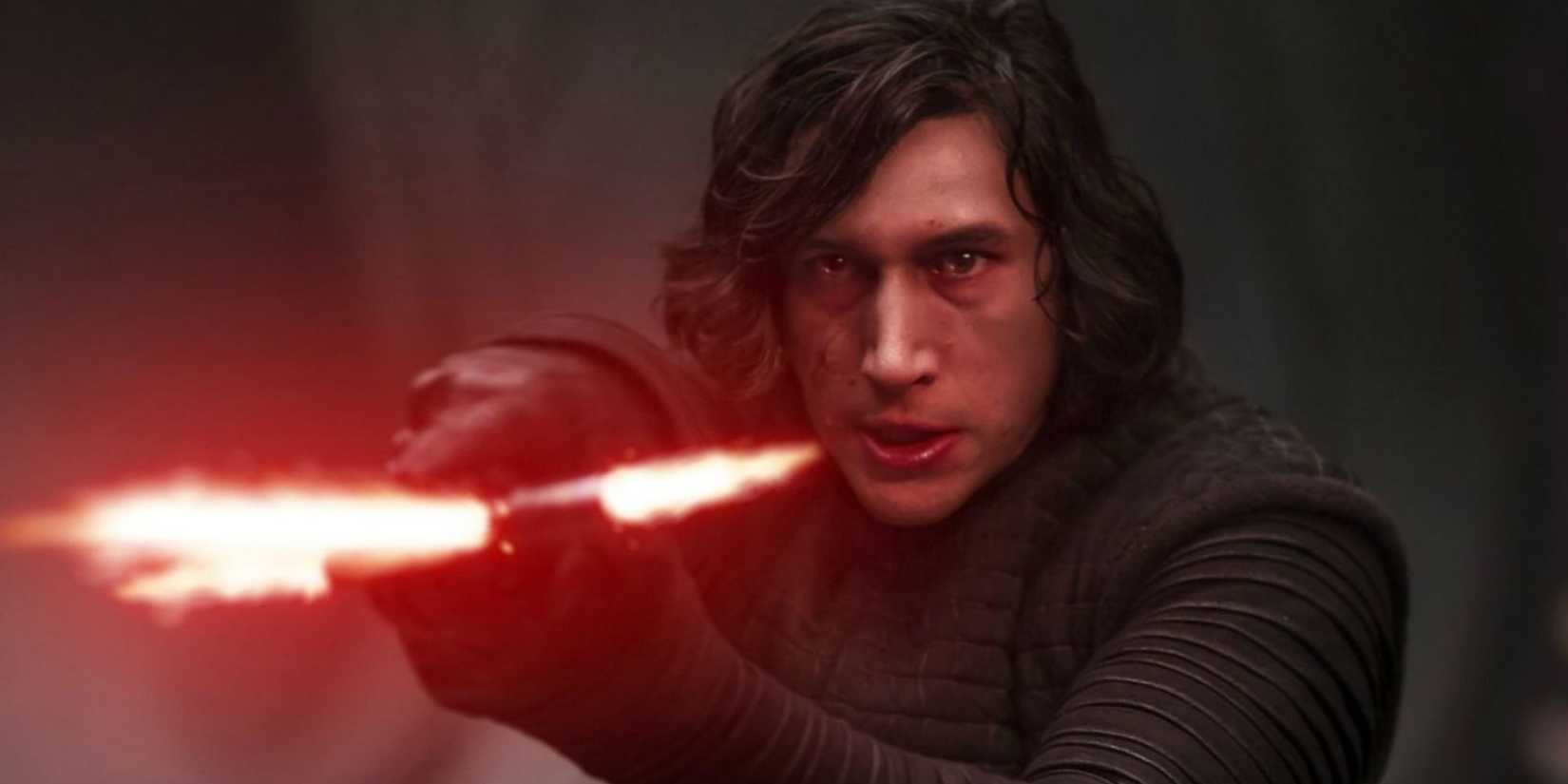 Kylo Ren, played by Adam Driver, holds his lightsaber forward in 'Star Wars: The Force Awakens'.