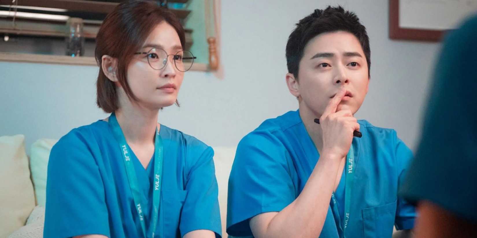 Chae Song Hwa and Lee Ik Jun from Hospital Playlist sitting together in their scrubs.