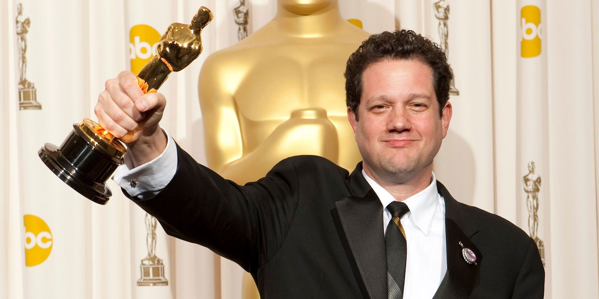 Michael Giacchino holding his Oscar at the event backstage