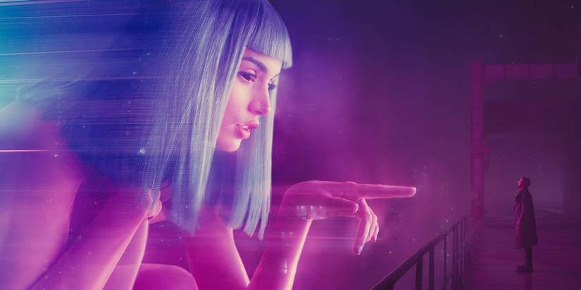 K (Ryan Gosling) standing beneath a hologram of Joi (Ana de Armas) in 'Blade Runner 2049' (2017).