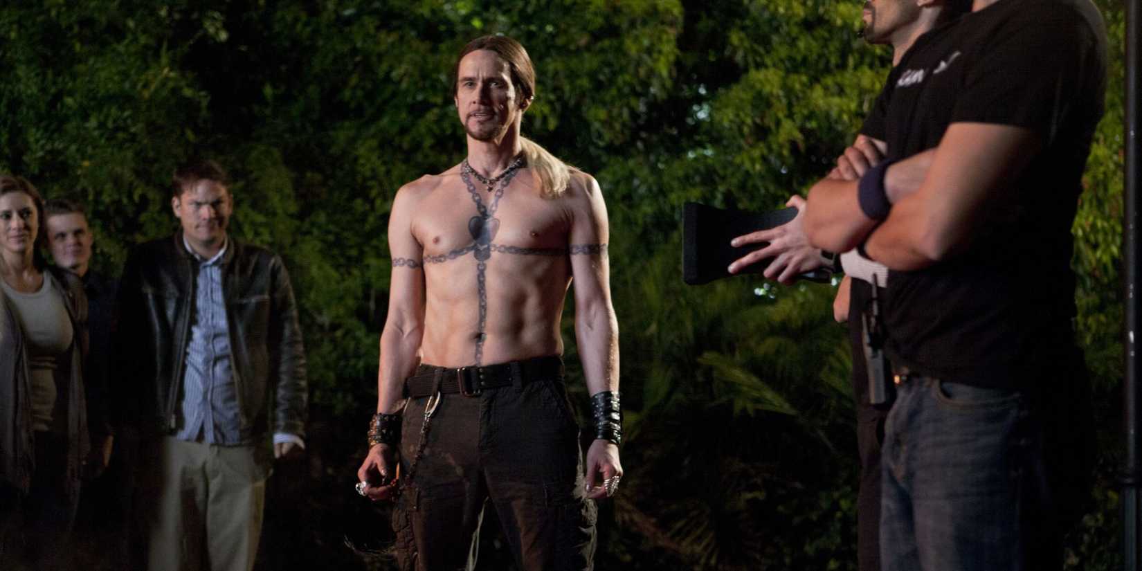 Jim Carrey as the street magician Steve Gray standing shirtless in the yard with people around him in The Incredible Burt Wonderstone