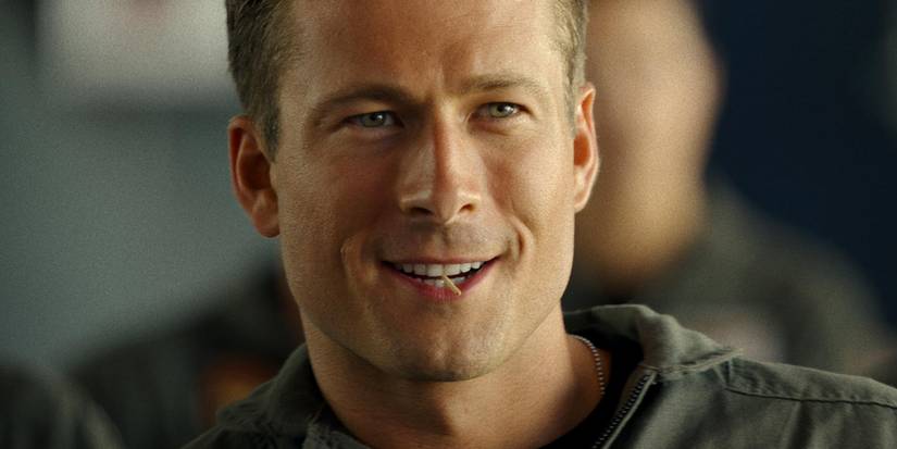 Glen Powell as LT Jake "Hangman" Seresin smiling in Top Gun: Maverick