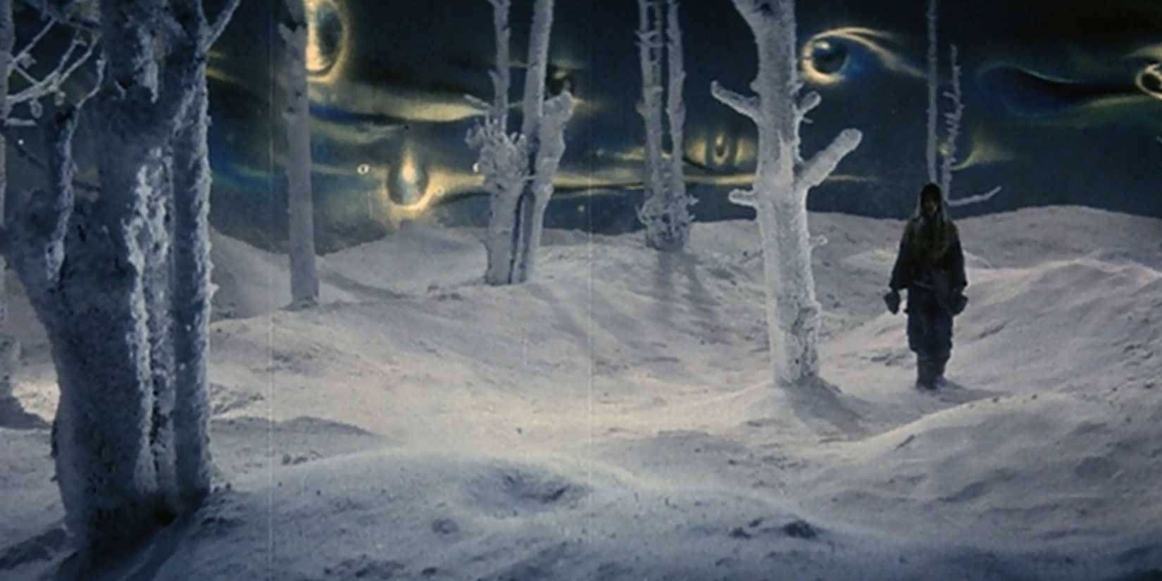 A man standing in a surreal snowy landscape with eyes in the sky in Kwaidan