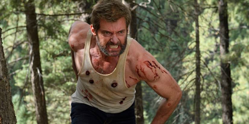 Hugh Jackman as Wolverine, bloodied and running angrily through the woods in Logan.