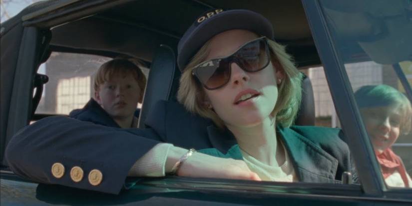 Kristen Stewart as Princess Diana in the passenger seat of a car with her sons in the back in Spencer.