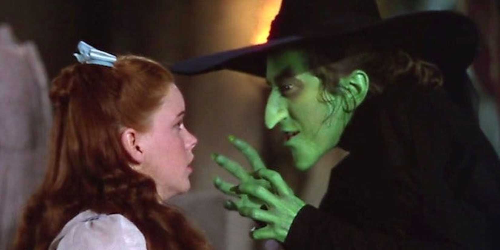 The Wicked Witch of the West (Margaret Hamilton) confronts Dorothy (Judy Garland) while Dorothy looks frightened in The Wizard of Oz