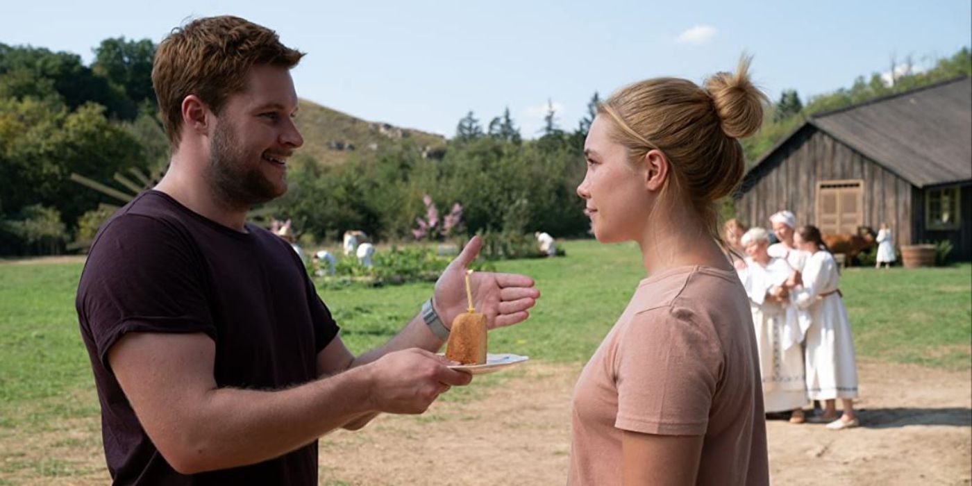 Jack Reynor giving Florence Pugh a piece of cake with a candle in 'Midsommar'.