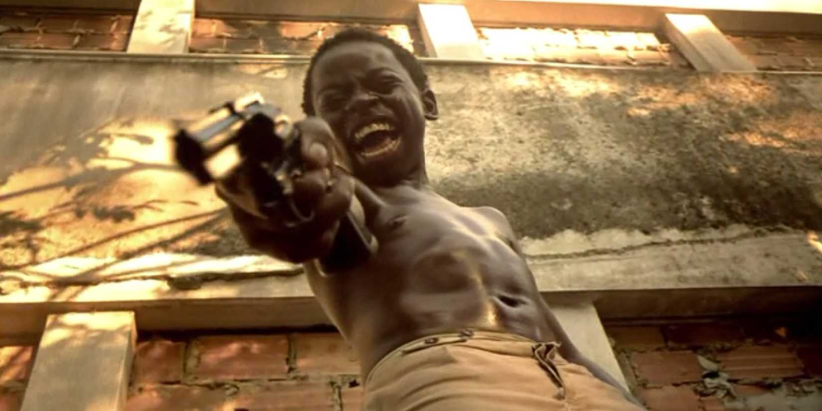 A young boy screaming while aiming a gun down at someone off camera in City of God - 2002