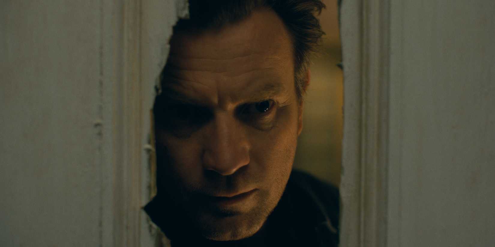 Dan Torrance (Ewan McGregor) looking through a broken door in 'Doctor Sleep'