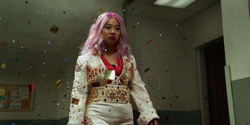 Stephanie Hsu as Jobu Tupaki walks down a hall with glitter falling in Everything Everywhere All at Once.