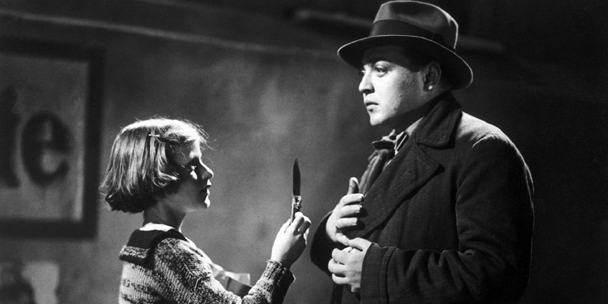 Hans Beckert with a girl in front of him flaunting a scalpel in M