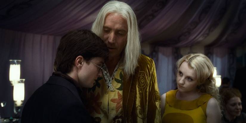 A blonde man is speaking to a brunette one while a blonde girl stands by and listens