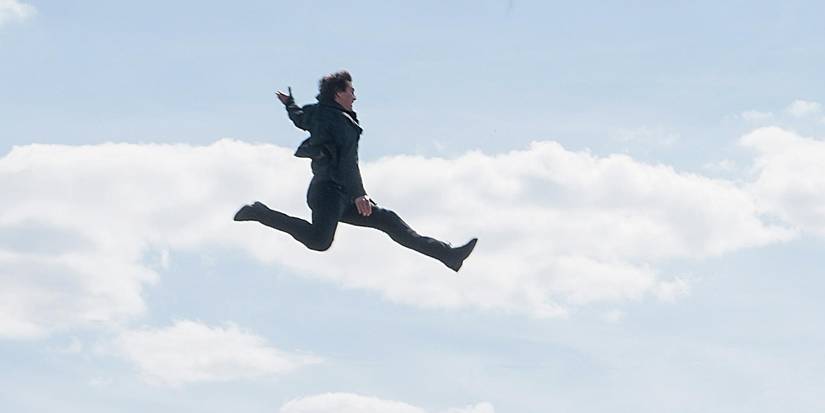 Ethan Hunt (Tom Cruise) leaps through the air from one building to another.
