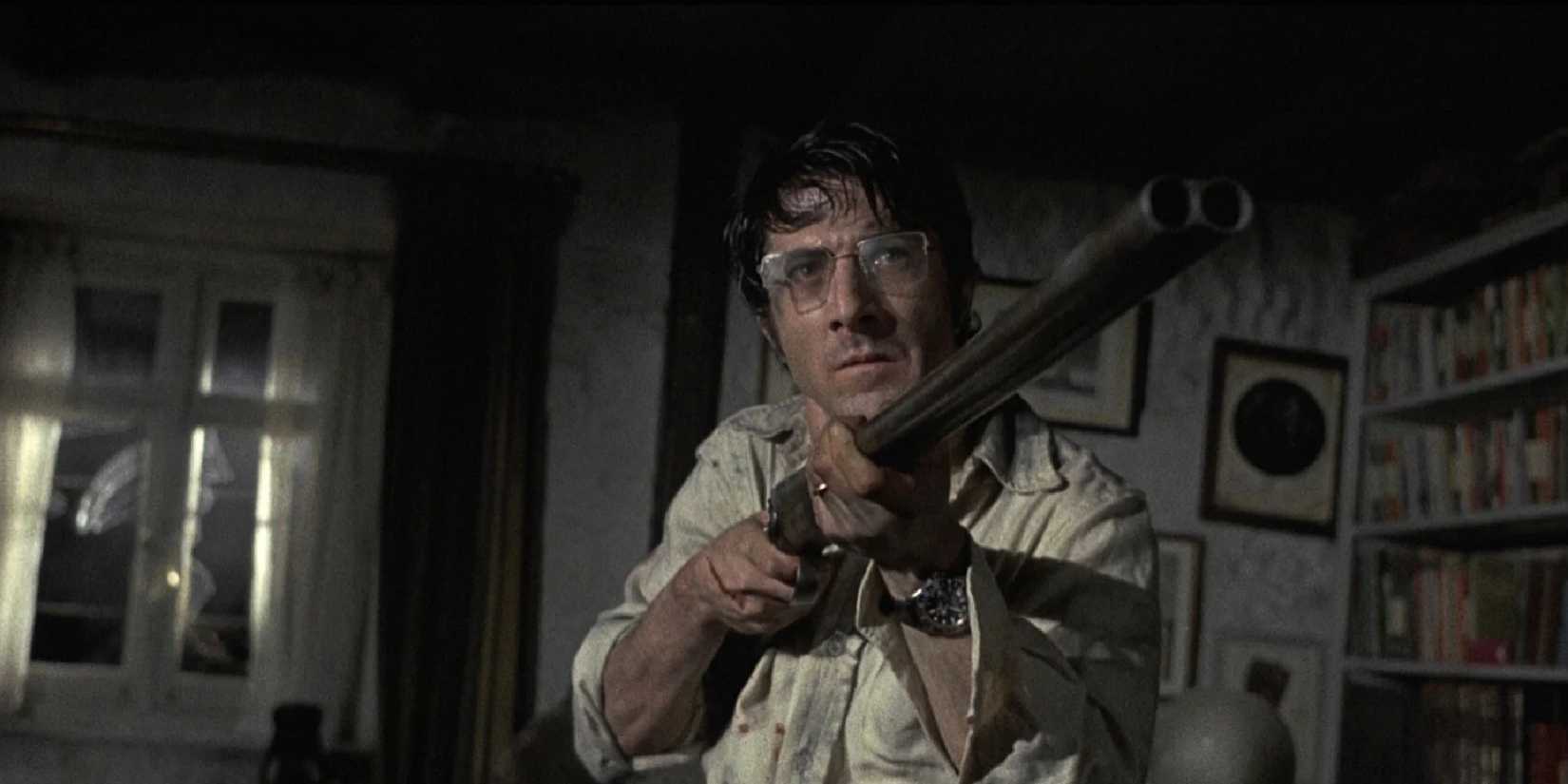 Dustin Hoffman as David Sumner holding a gun in Straw Dogs.