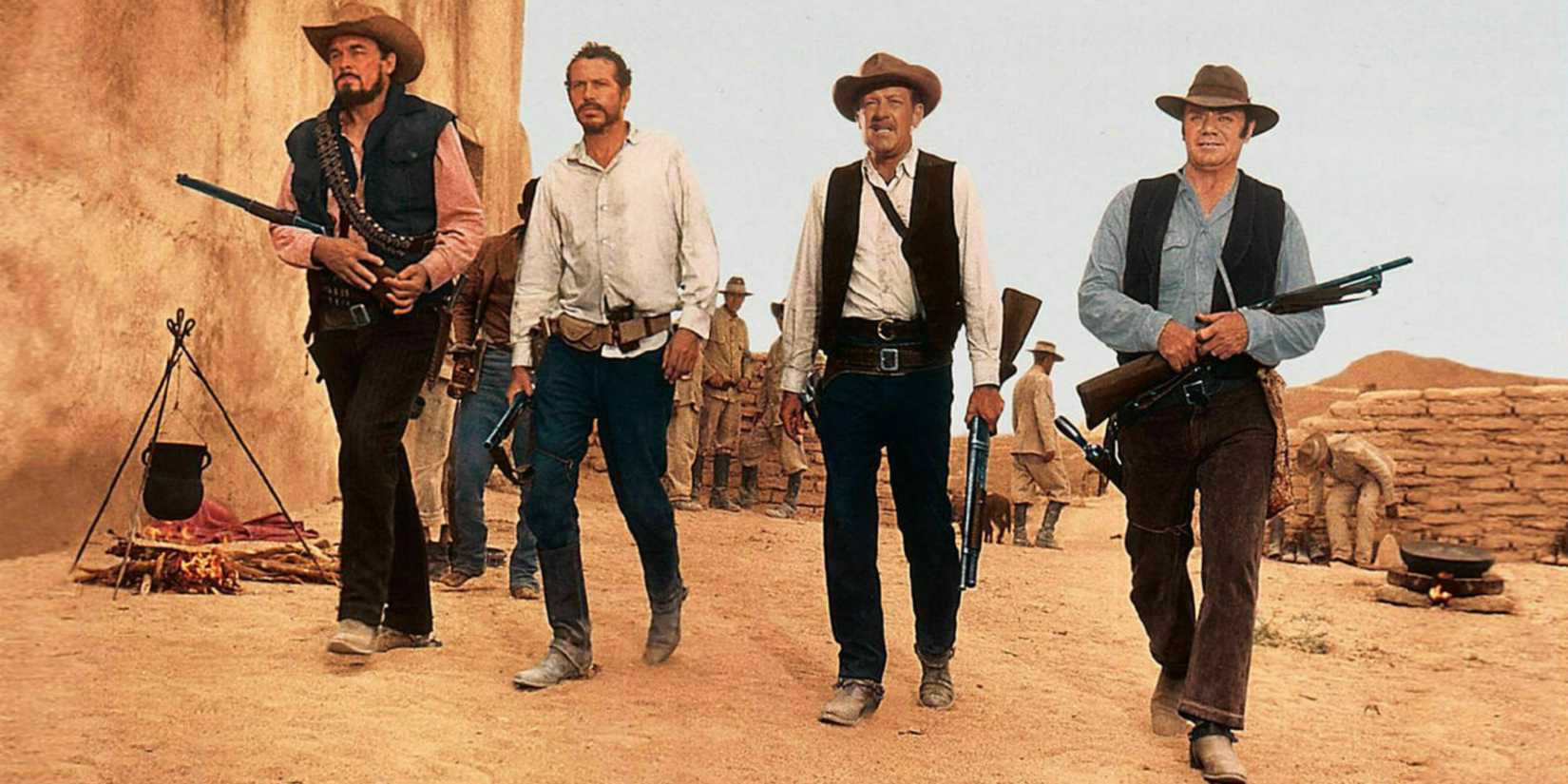 William Holden, Ernest Borgnine, Ben Johnson, and Warren Oats walking with weapons in The Wild Bunch.