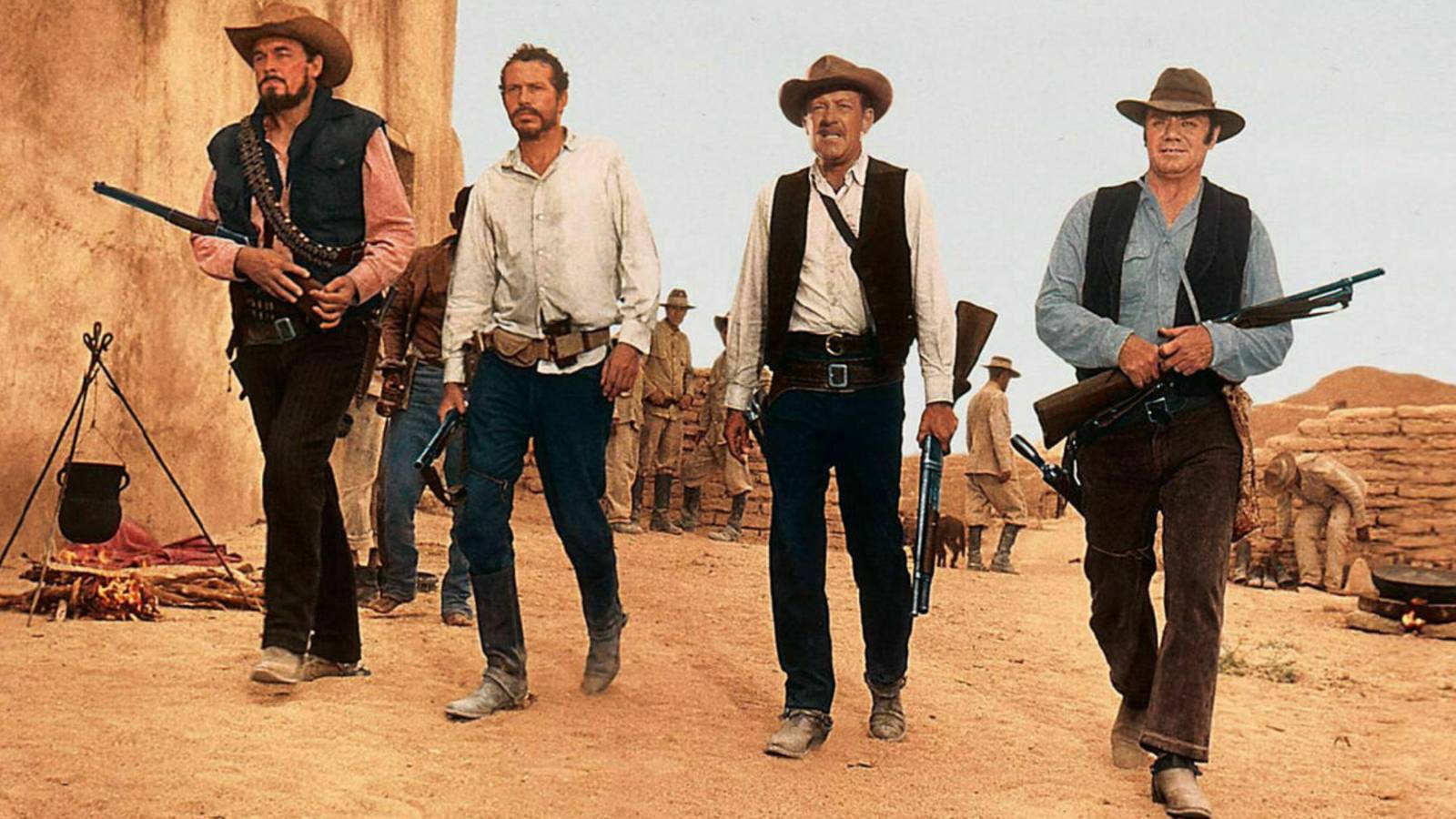 William Holden, Ernest Borgnine, Ben Johnson, and Warren Oats walking with weapons in The Wild Bunch.