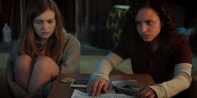 Fear Street's Sam (Olivia Scott Welch) and Deena (Kiana Madeira) sitting on the floor together looking stressed