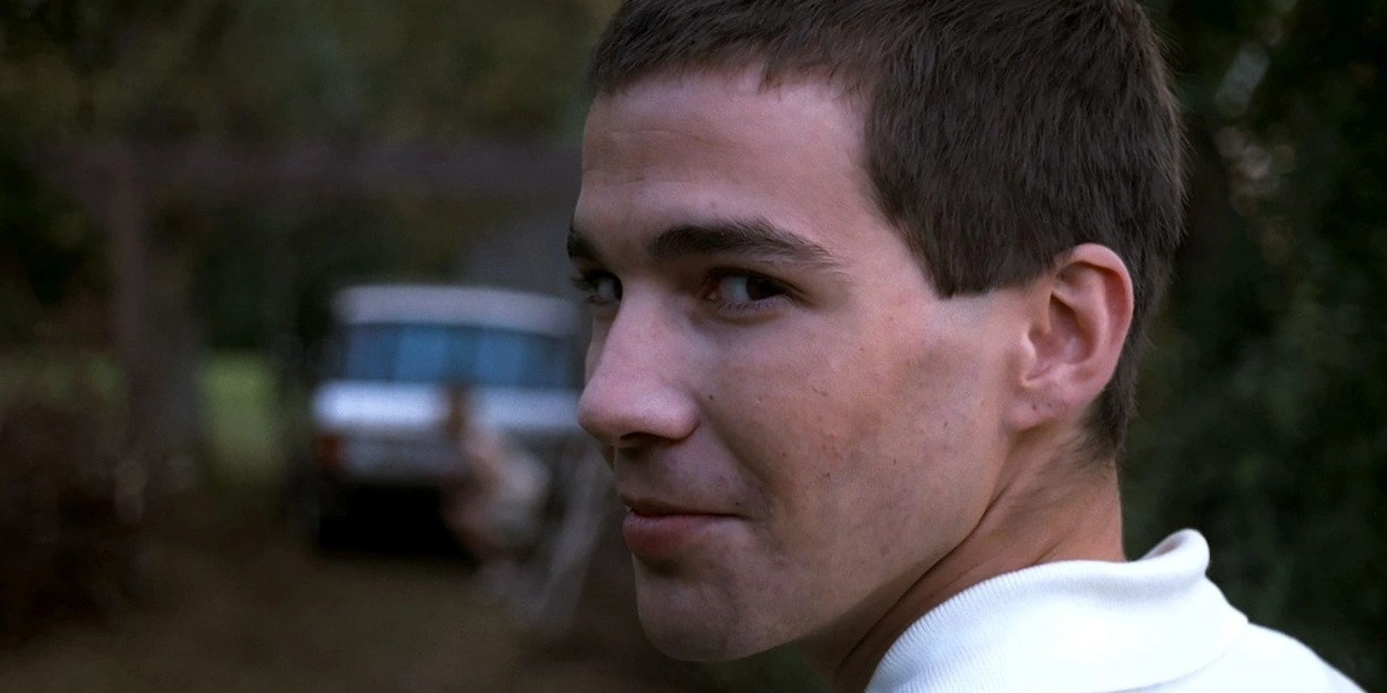 A young man turning around to smirk at the camera in Funny Games