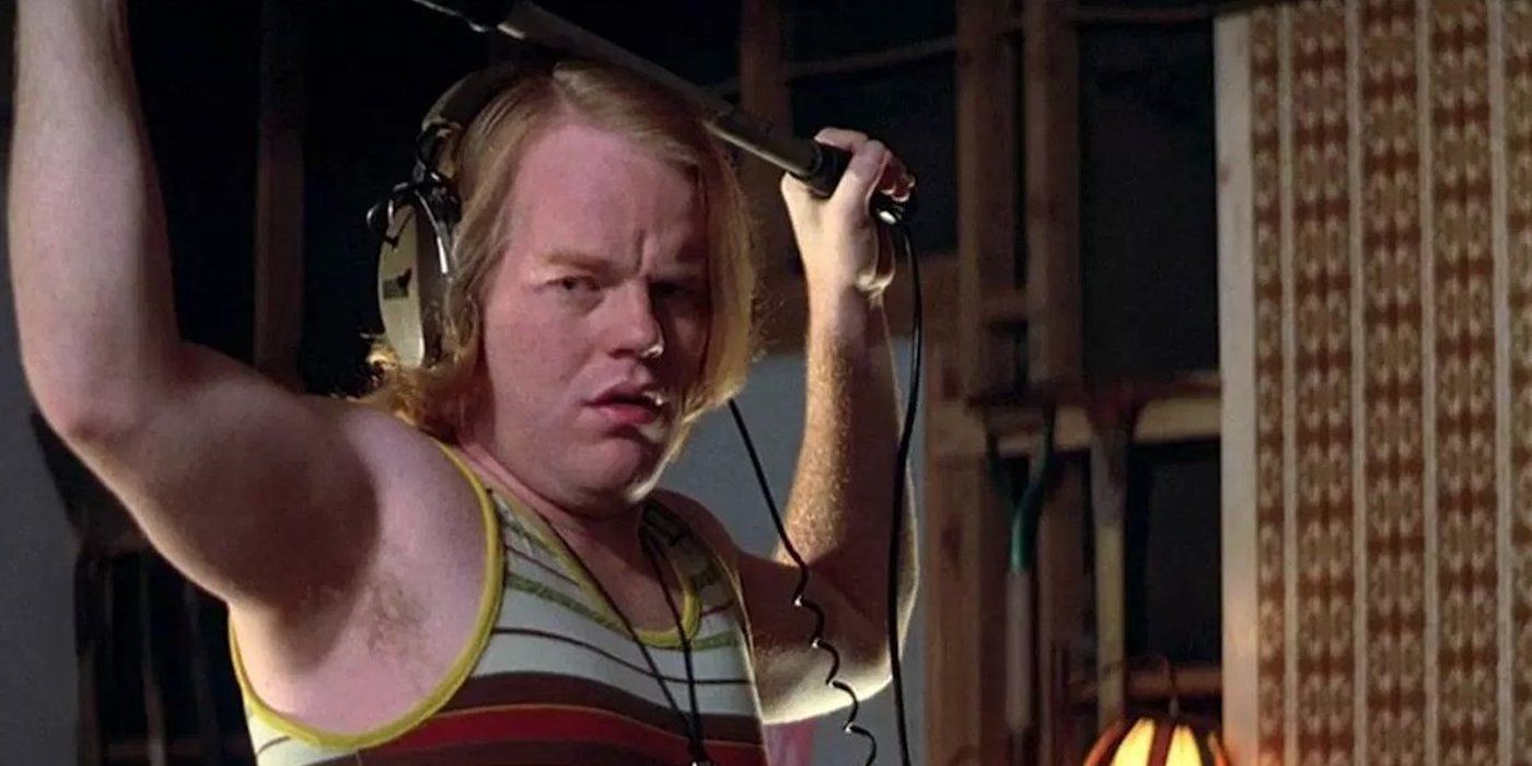 Philip Seymour Hoffman as Scotty J, holding a boom mic, on a fictional set in Boogie Nights