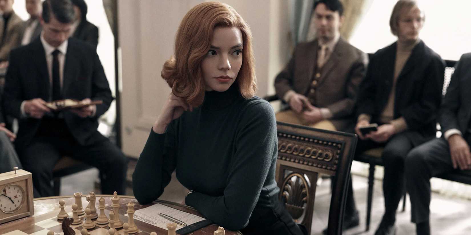 Anya Taylor-Joy as Beth Harmon, sitting in front of a chess board in The Queen's Gambit.