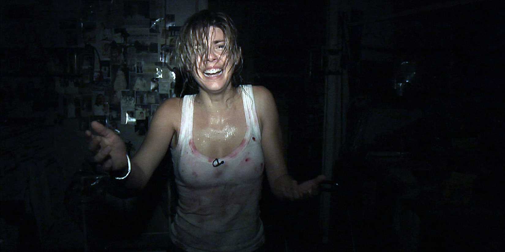 Angela (Manuela Velasco) stands in the dark, looking frightened in REC.