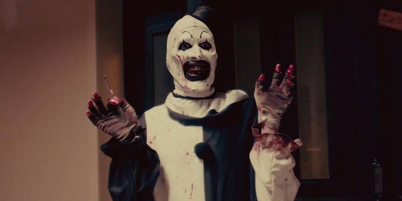 David Howard Thornton as Art the Clown waving his bloody hands gleefully in Terrifier 2