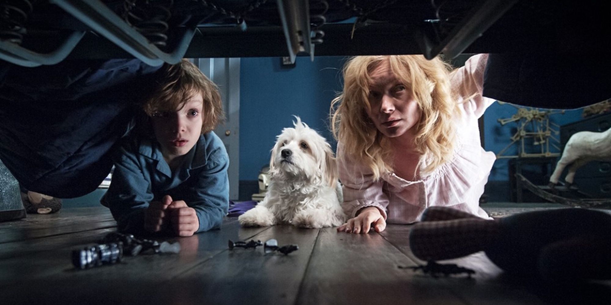 A mother and her son (Noah Wiseman and Essie Davis) look under the bed for monsters in The Babadook.