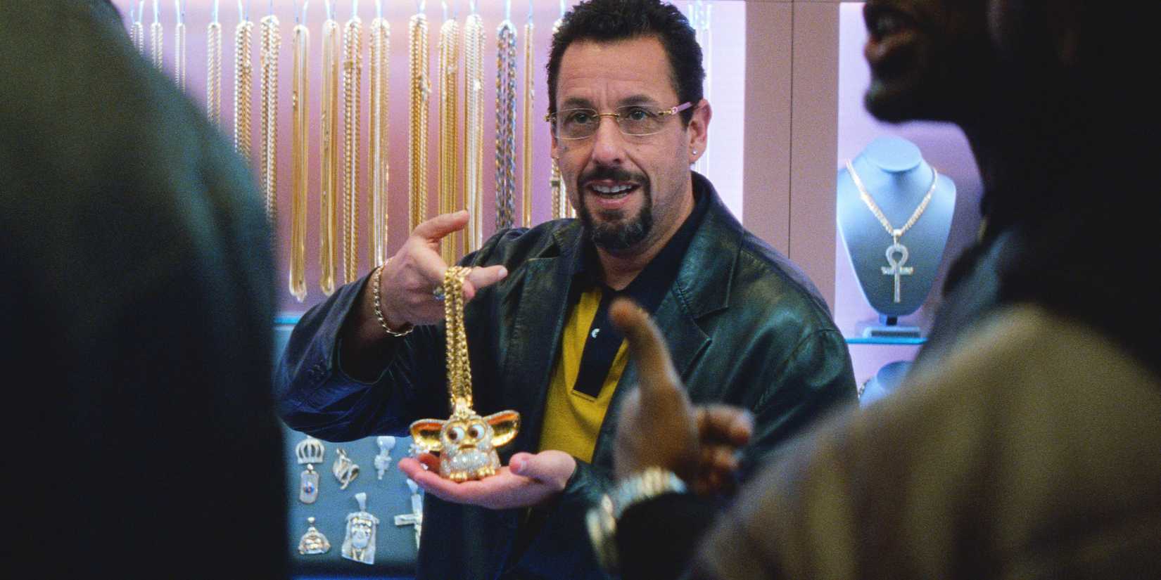 Adam Sandler showing off a gold necklace in Uncut Gems
