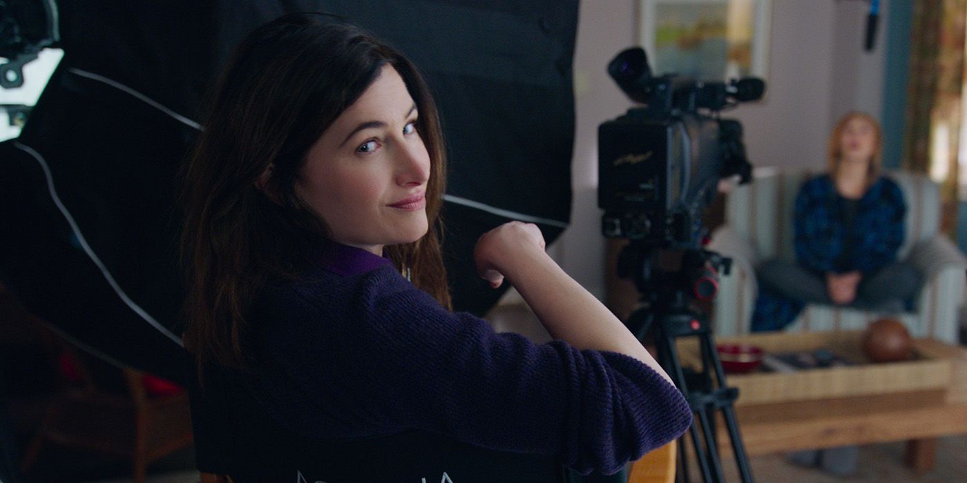 Kathryn Hahn as Agatha Harkness looking into the camera over the back of a director's chair in WandavVision