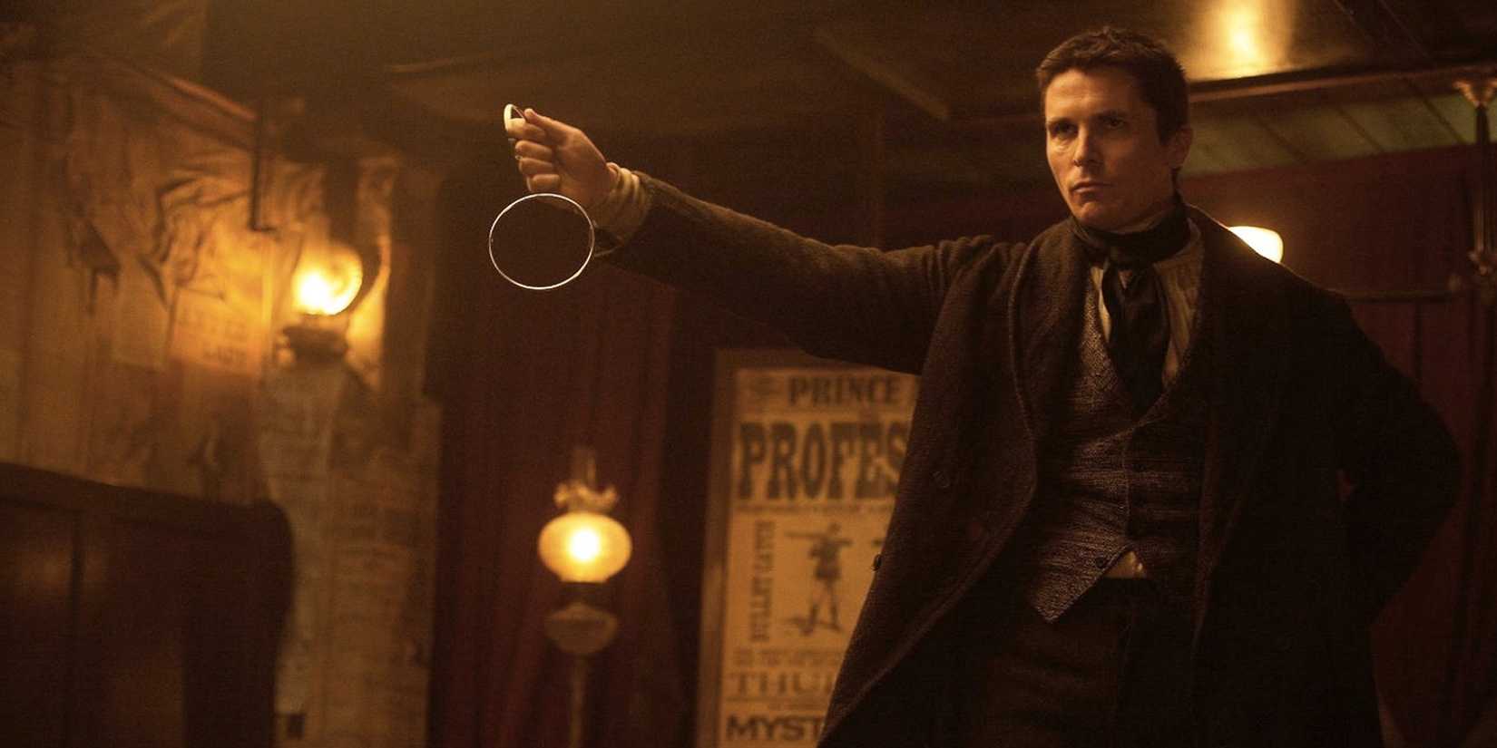 Christian Bale as Alfred Borden, holding up a pair of linking rings in 'The Prestige'