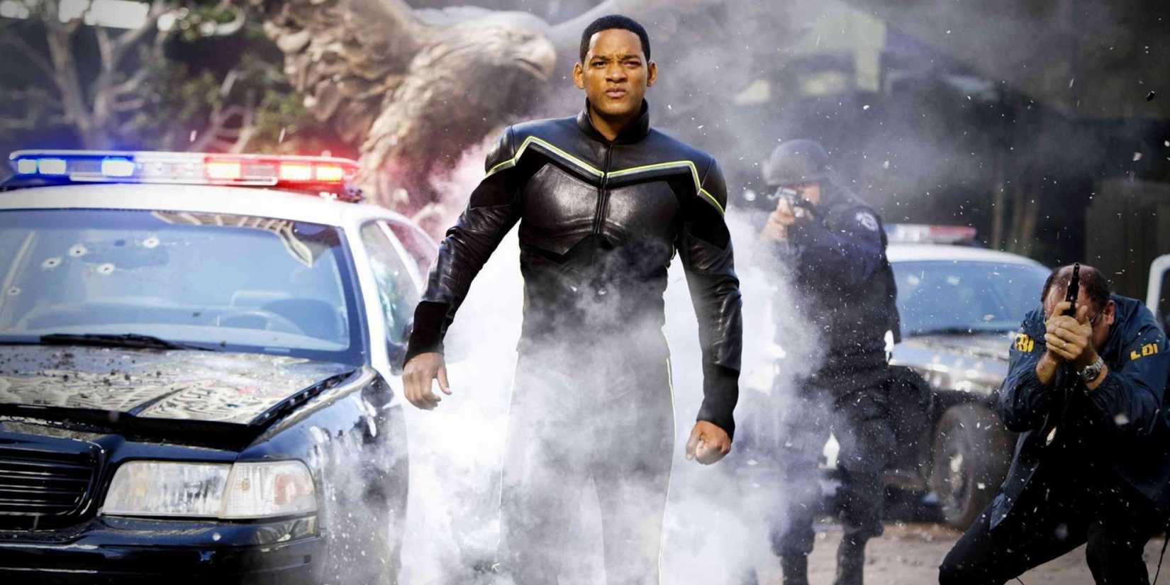 Will Smith as John Hancock walking through a spray of bullets in a police showdown in Hancock