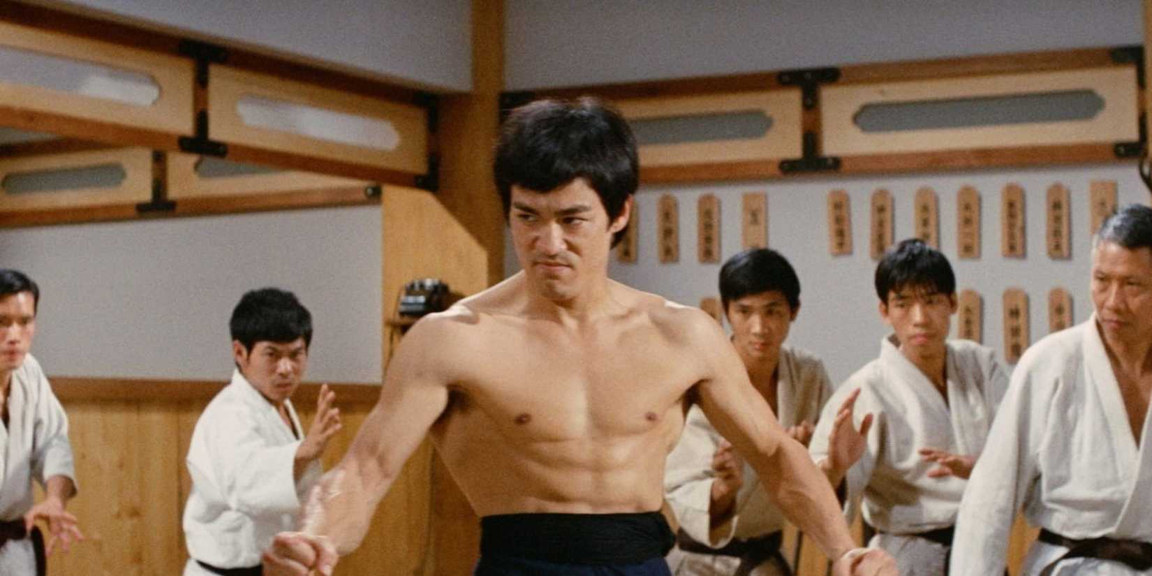 Bruce Lee flexing his core in a dojo in Fist of Fury (1972).
