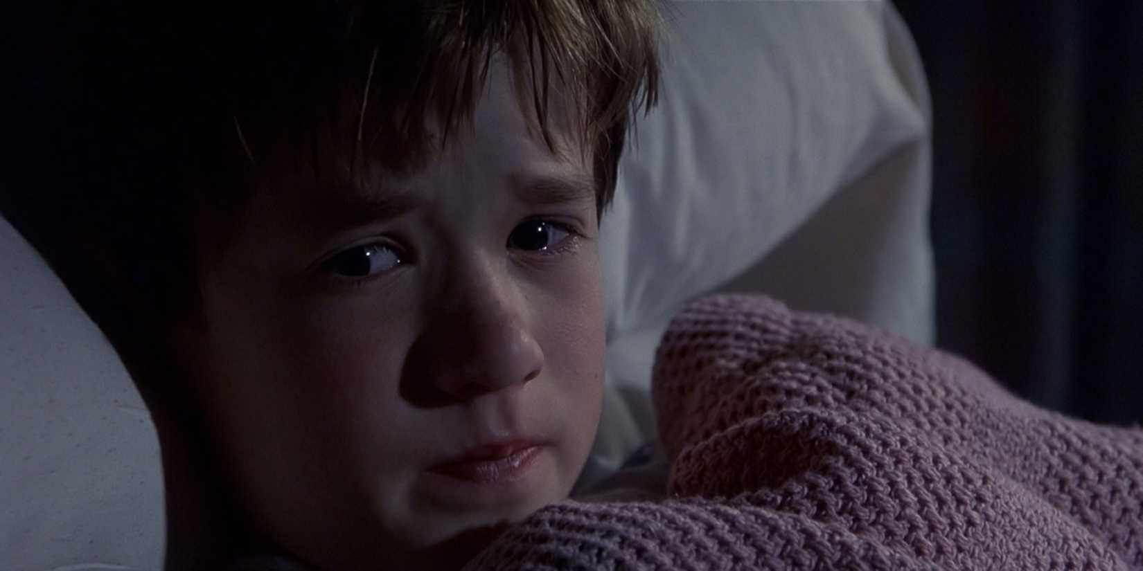 Cole Sear is lying in bed, scared, in the "I see dead people" scene of The Sixth Sense.