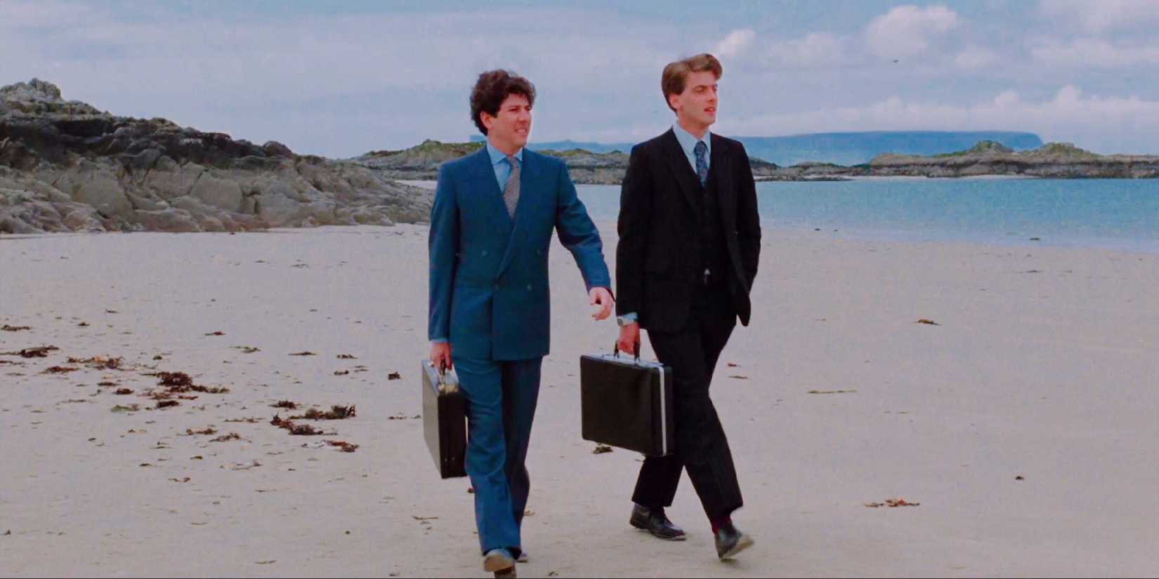 Mac and Oldsen are walking on a beach wearing suits and carrying briefcases in Local Hero.