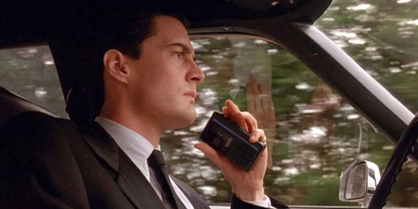 Kyle MacLachlan as Dale Cooper, driving and looking serious in Twin Peaks